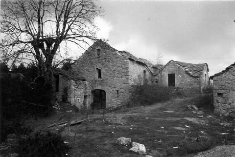 Maisons en ruine sous un ciel gris, photographie en noir et blanc