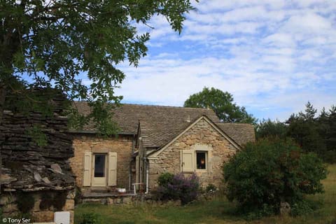 Les Huttes et la maison voisine sous le ciel bleu